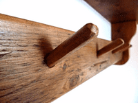 Rustic wooden shelf with coat pegs.
